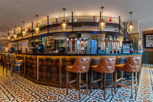 a bar with brown stools in a room at The Bold Hotel; BW Signature Collection in Southport