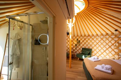 a room with a bed and a shower in a yurt at Yurta Glamping B&B San Leone Agrigento - tra mare e pineta in Agrigento