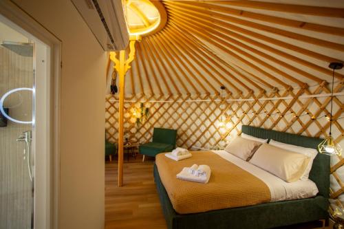 a bedroom with a bed with two towels on it at Yurta Glamping B&B San Leone Agrigento - tra mare e pineta in Agrigento