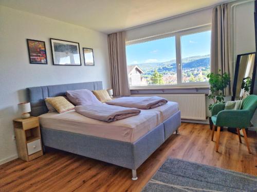 a bedroom with a bed and a large window at FeWo Talblick - modern, charmant, Feldrand in Bad Orb