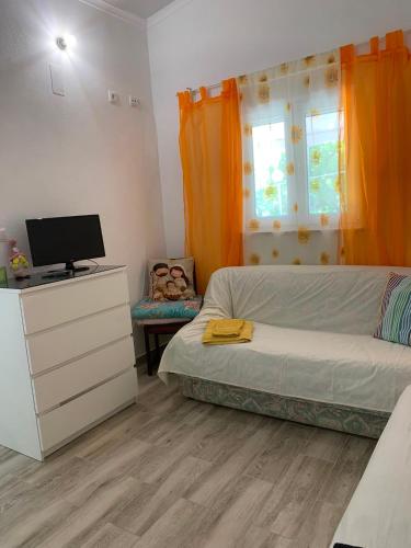 a bedroom with a bed and a dresser with a television at Quarto privado na natureza in Fernao Ferro