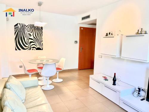 a living room with a table and a zebra picture on the wall at Alcocebre suites INALKO in Alcalà de Xivert