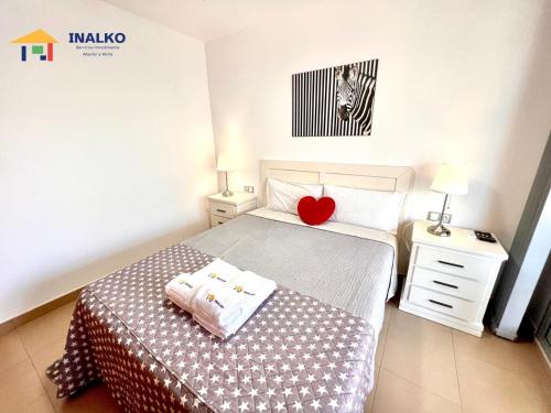 a bedroom with a bed with a heart pillow on it at Alcocebre suites INALKO in Alcalà de Xivert