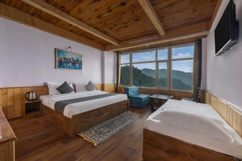 a bedroom with two beds and a television in a room at Narkanda Heights by Splendid Retreat Hotels in Nārkanda