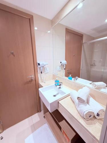 a bathroom with a sink and a large mirror at SOFISTICADO Flat Brasília no Eixo Monumental, Melhor Localização de Brasília in Brasília