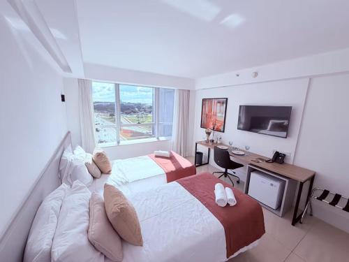a hotel room with a large bed and a television at SOFISTICADO Flat Brasília no Eixo Monumental, Melhor Localização de Brasília in Brasília