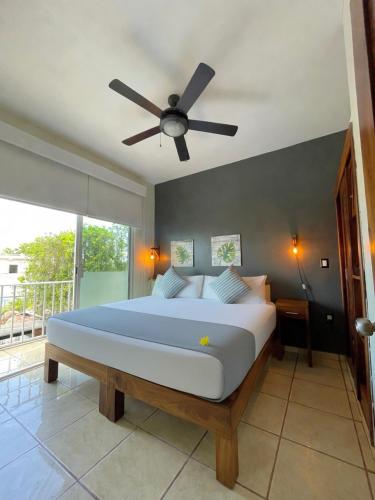 a bedroom with a large bed with a ceiling fan at Punto Mita Eco Surf Suites in Punta Mita