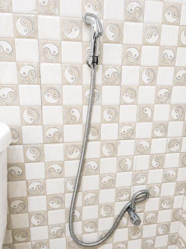 a shower head in a bathroom with a tiled floor at Home23 Apartments in Jinja