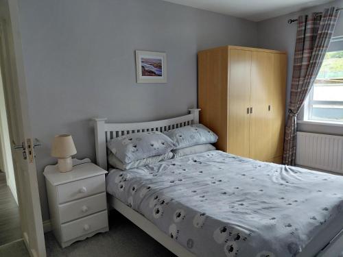 a bedroom with a bed and a wooden cabinet at Cottage - Sleeps 6 - Parking in Letterkenny