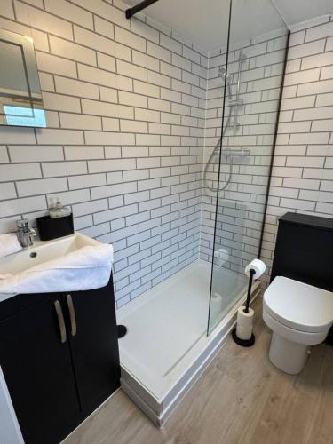 a bathroom with a shower and a toilet and a sink at Modern 3BR home in Cumbernauld in Cumbernauld