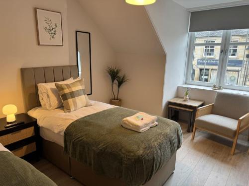 a bedroom with a bed and a chair and a window at Modern 3BR home in Cumbernauld in Cumbernauld