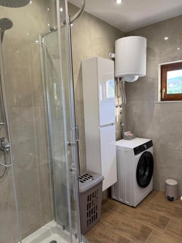 a bathroom with a shower and a washing machine at Apartment Sidro in Posedarje