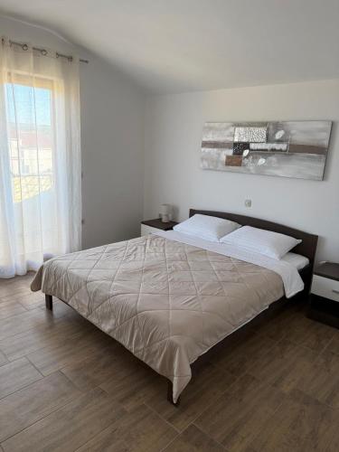 a bedroom with a bed and a large window at Apartment Sidro in Posedarje