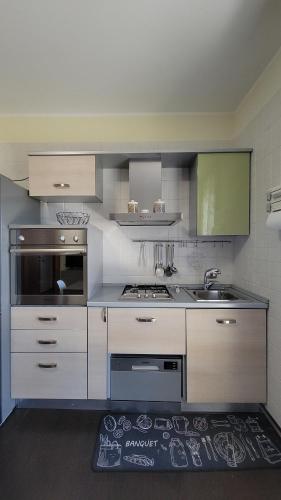 a kitchen with white cabinets and a sink at Il Tramonto in Elmas