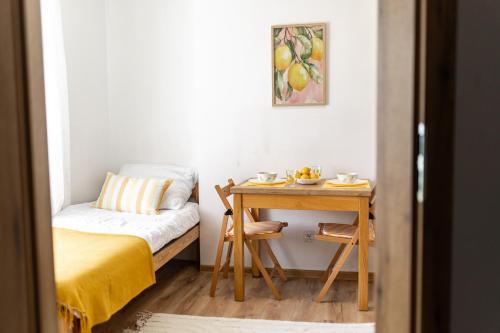 a small room with a bed and a desk with a table at Apartament Cytrynowy Kwidzyn in Kwidzyn