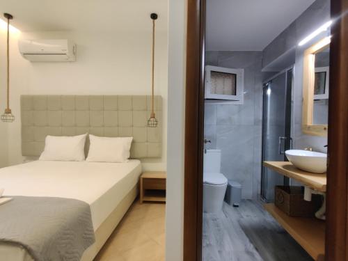 a bedroom with a bed and a bathroom with a sink at Verde Villas in Skala Potamias