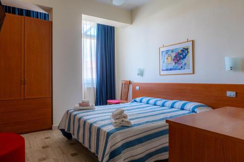 a bedroom with a bed with towels on it at Little Garden in Formia