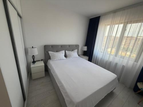 a bedroom with a white bed and a window at Royal Five Urban in Bucharest