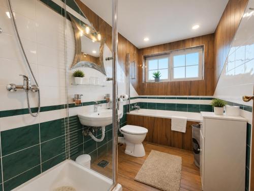 a bathroom with a tub and a sink and a toilet at Villa Spa Magic in Tuheljske Toplice