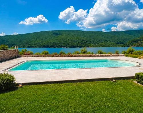 a swimming pool with a lake in the background at LUX Villa Mavrovo in Mavrovo