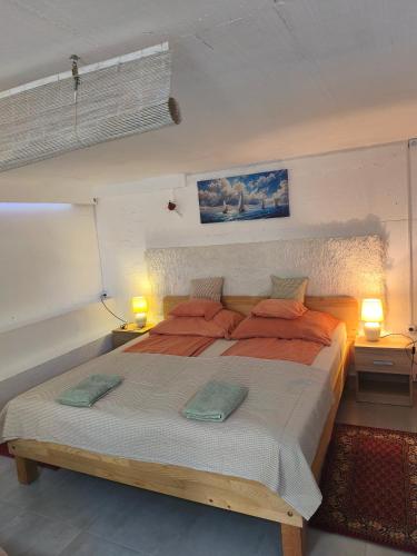 a bedroom with a large bed with orange pillows at Slanraj Studio in Jadrtovac