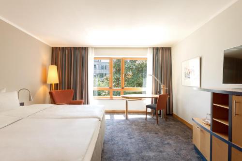 a hotel room with a bed and a table and a window at Hotel Remarque in Osnabrück