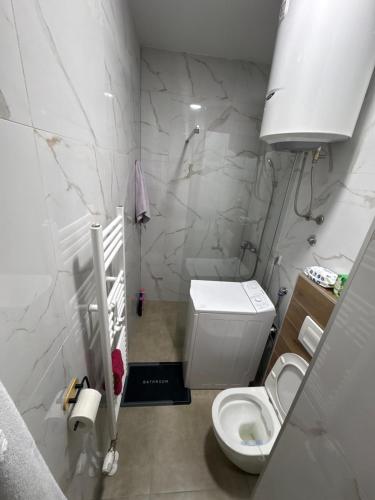 a white bathroom with a toilet and a sink at Modern Apartment Laktaši in Laktaši
