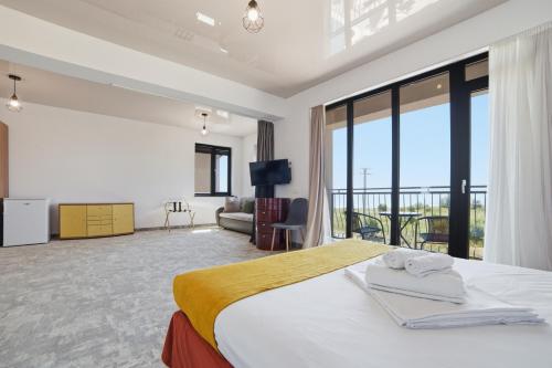 a hotel room with a bed and a large window at Complex PopDan in Costinesti