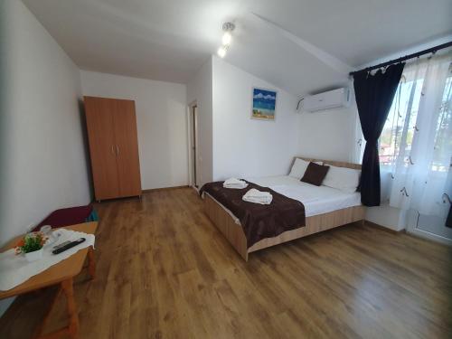 a bedroom with a bed and a table in it at Casa cu flori in Tuzla