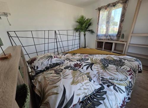 a bedroom with a bed with a floral bedspread at La Casadrine in Le Grau-dʼAgde