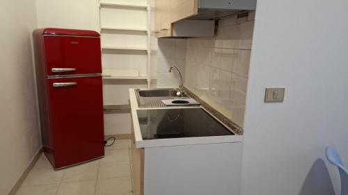 a kitchen with a red refrigerator and a sink at Costadeiapartments in Briatico