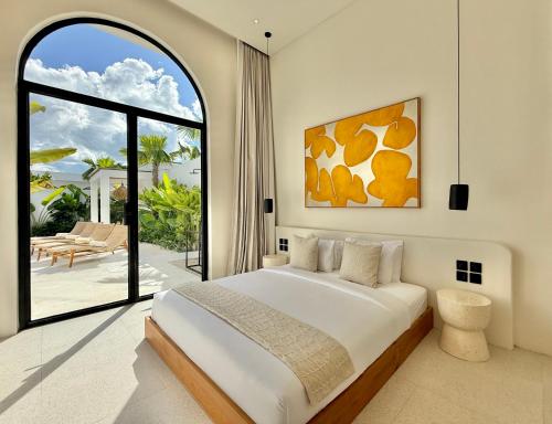 a bedroom with a large bed and a large window at Dolce x The Young Villas in Uluwatu