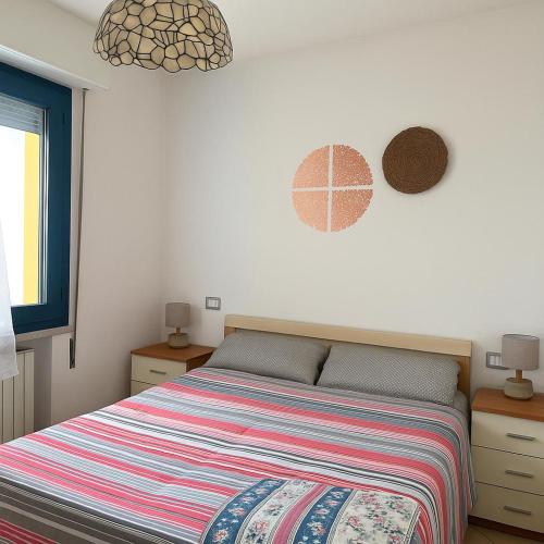a bedroom with a bed with a colorful striped comforter at art apartament cerea in Cerea