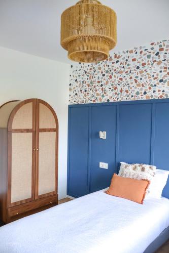 a bedroom with a bed with a blue headboard at Alazne Enea in Bermeo