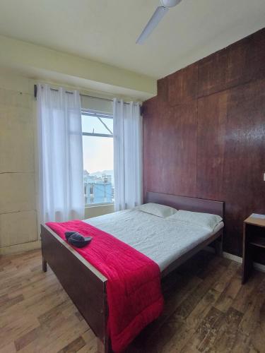 a bedroom with a bed with a red blanket on it at Mizotel in Āīzawl