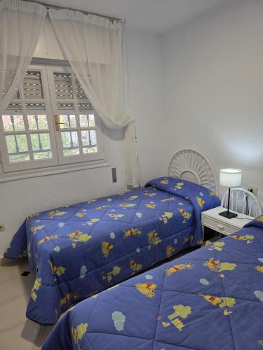 a bedroom with two beds and a window at Duplex Los Chanchez in Aguadulce