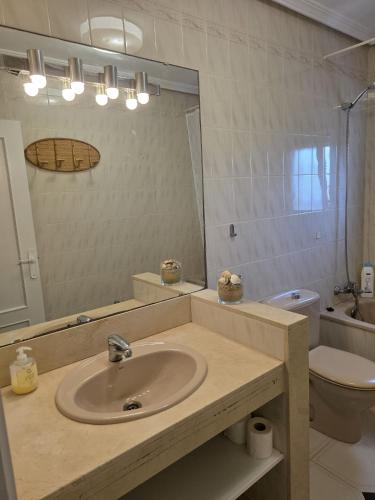 a bathroom with a sink and a toilet and a mirror at Duplex Los Chanchez in Aguadulce
