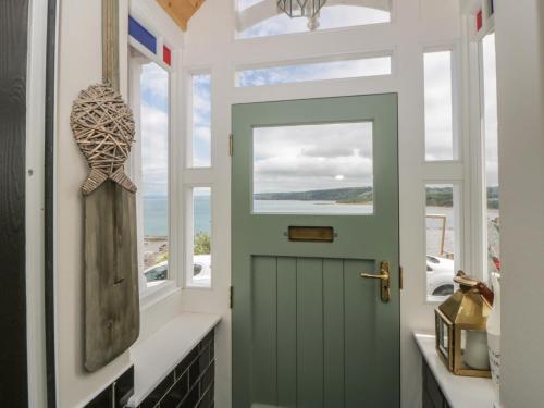 a green door in a hallway with a window at Arosfa in New Quay
