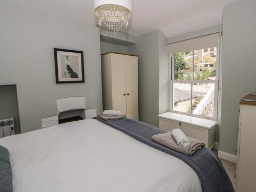 a bedroom with a large white bed and a window at Arosfa in New Quay