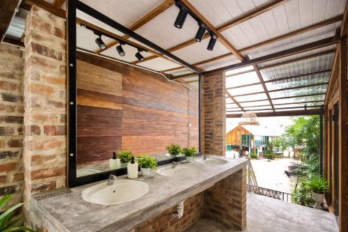 a bathroom with two sinks and a brick wall at Seaside Dorm Cenang in Pulau Tepur