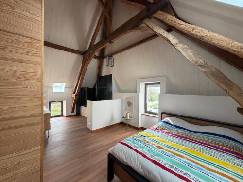 a bedroom with a bed in a room with wooden floors at Gîte Les Jacquets in Hautefort
