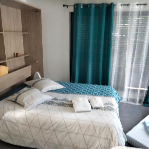 a bedroom with a large bed with a blue curtain at Au petit Mittlach in Mittlach
