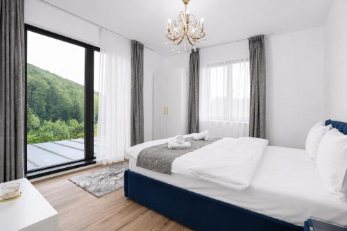 a bedroom with a bed and a large window at Cataleya House Sovata in Sovata