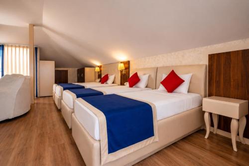 a row of four beds in a room at Kleopatra Micador Otel in Alanya