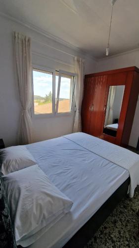 a bedroom with a large white bed and two windows at Xilagani Central House in Xilaganí