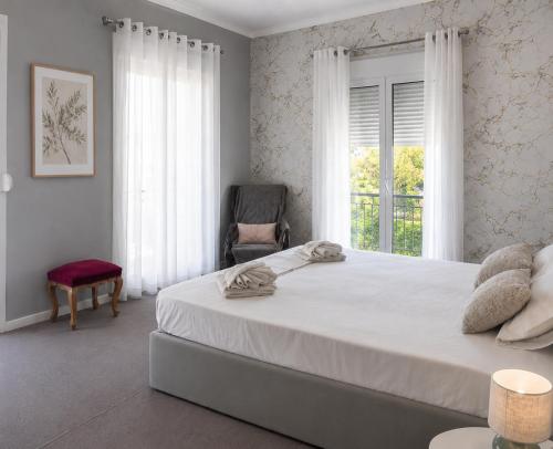 a bedroom with a bed and a chair and a window at Aggelina's Apartment in Zakynthos