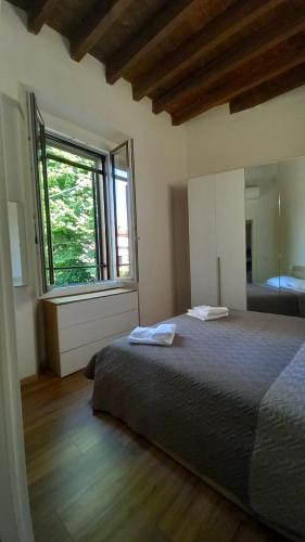 ein Schlafzimmer mit einem Bett und einem großen Fenster in der Unterkunft Camillo Benso in Bernareggio