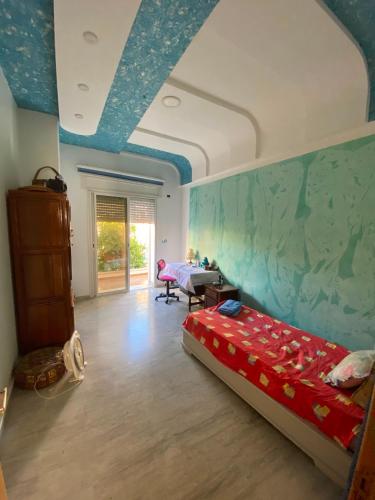 a bedroom with a bed and a blue ceiling at Villa CULUPIA in Kelibia
