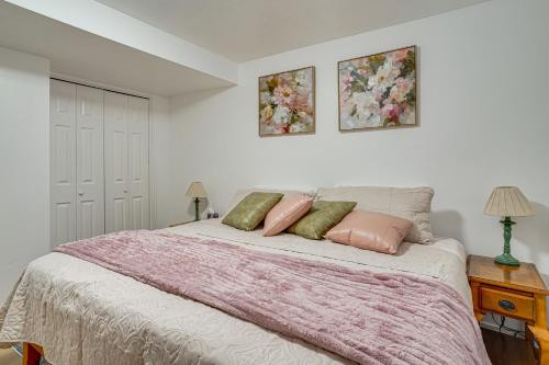 a bedroom with a bed with pink and green pillows at Utah Valley Basecamp: Apt for Hikers & Explorers! in Spanish Fork