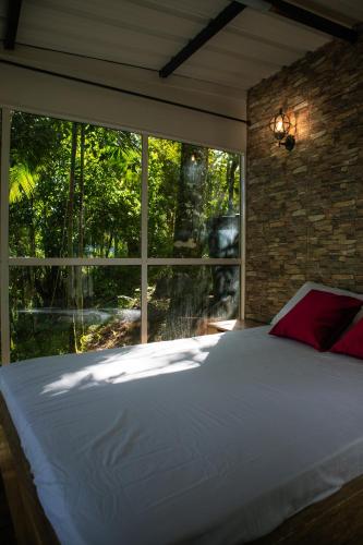 a large bed in a room with a large window at Natural Glamping Cocorna in Cocorná